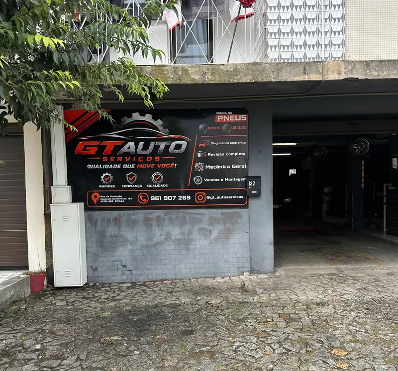 Entrada da GT Auto Serviços em Braga, com a placa da oficina por cima do portão